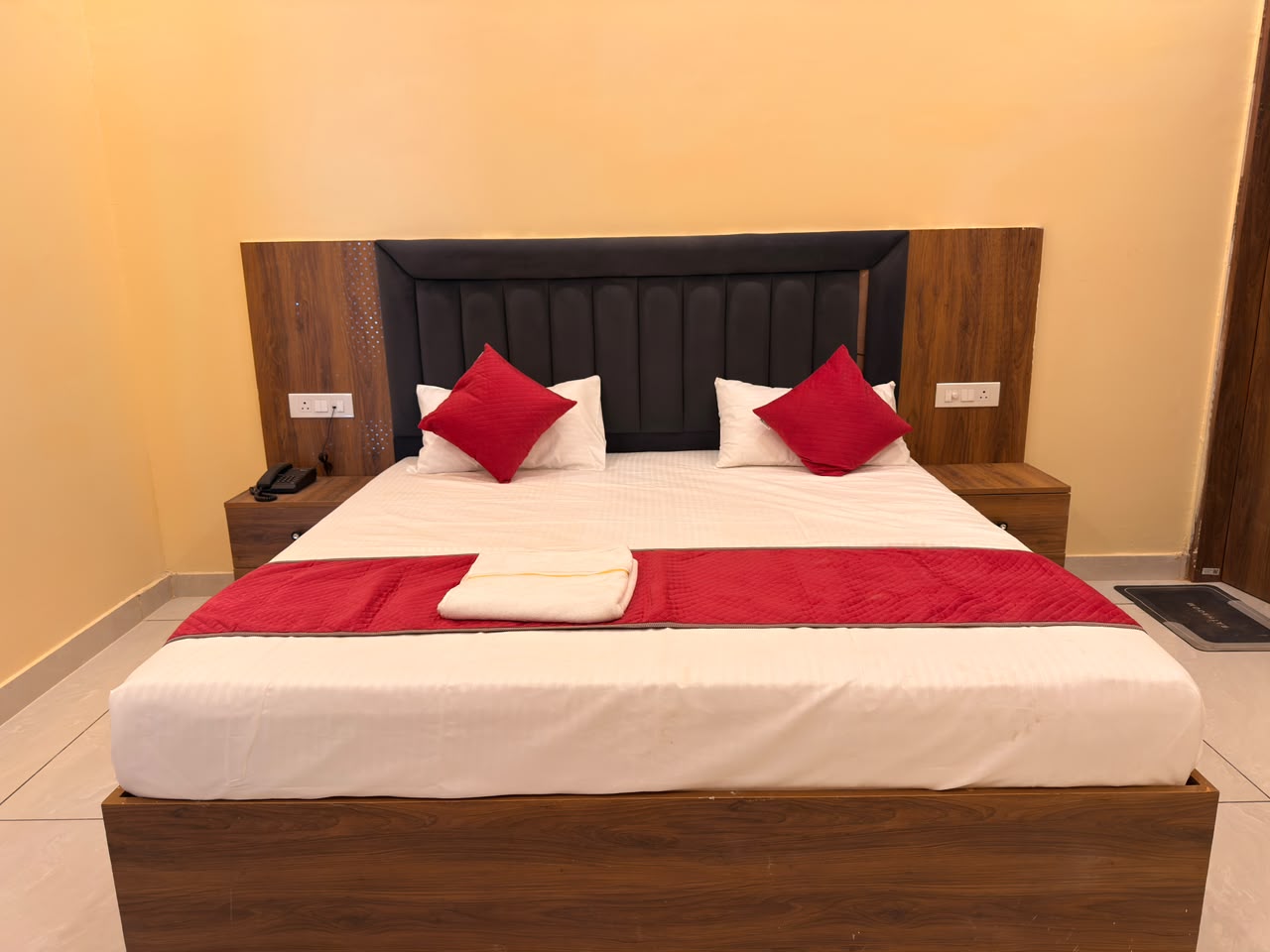 Guest room with large bed at Vedic Portico Hotel